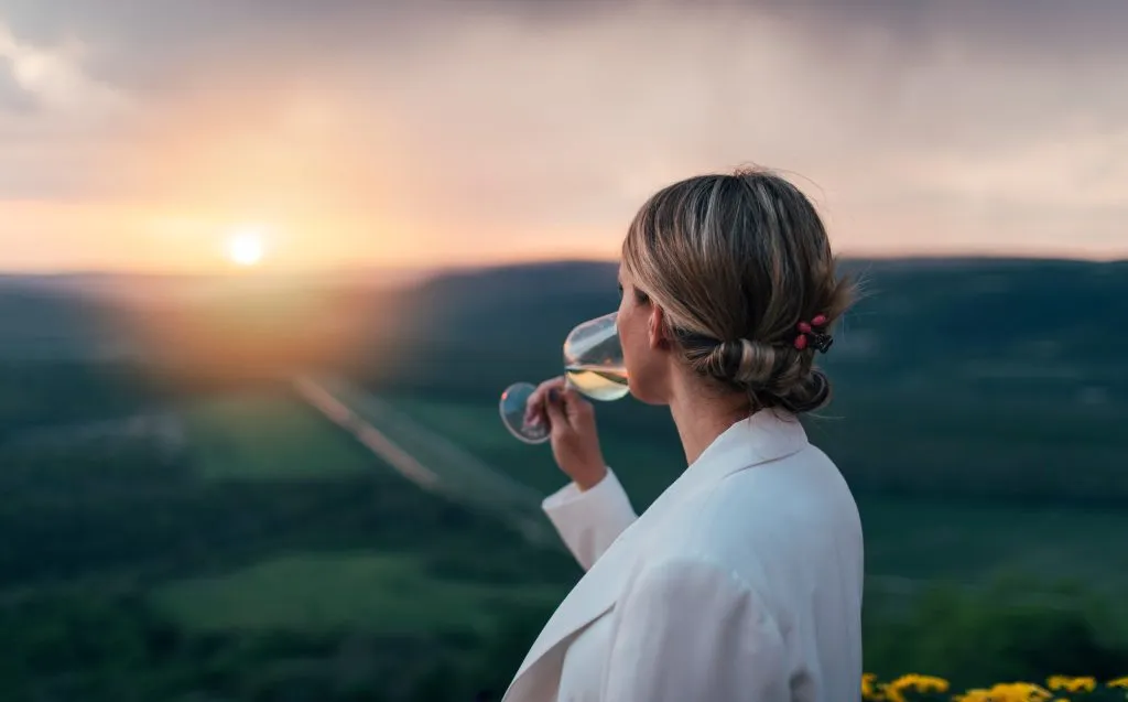 Seitenansicht einer Frau beim Verkosten von Weißwein